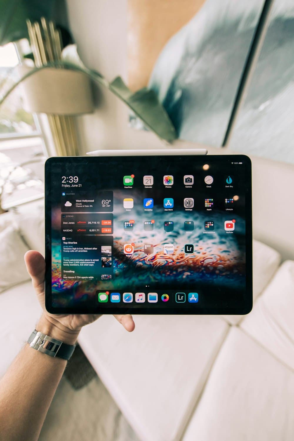 iPad tenu en main avec son stylet (photo d'illustration)