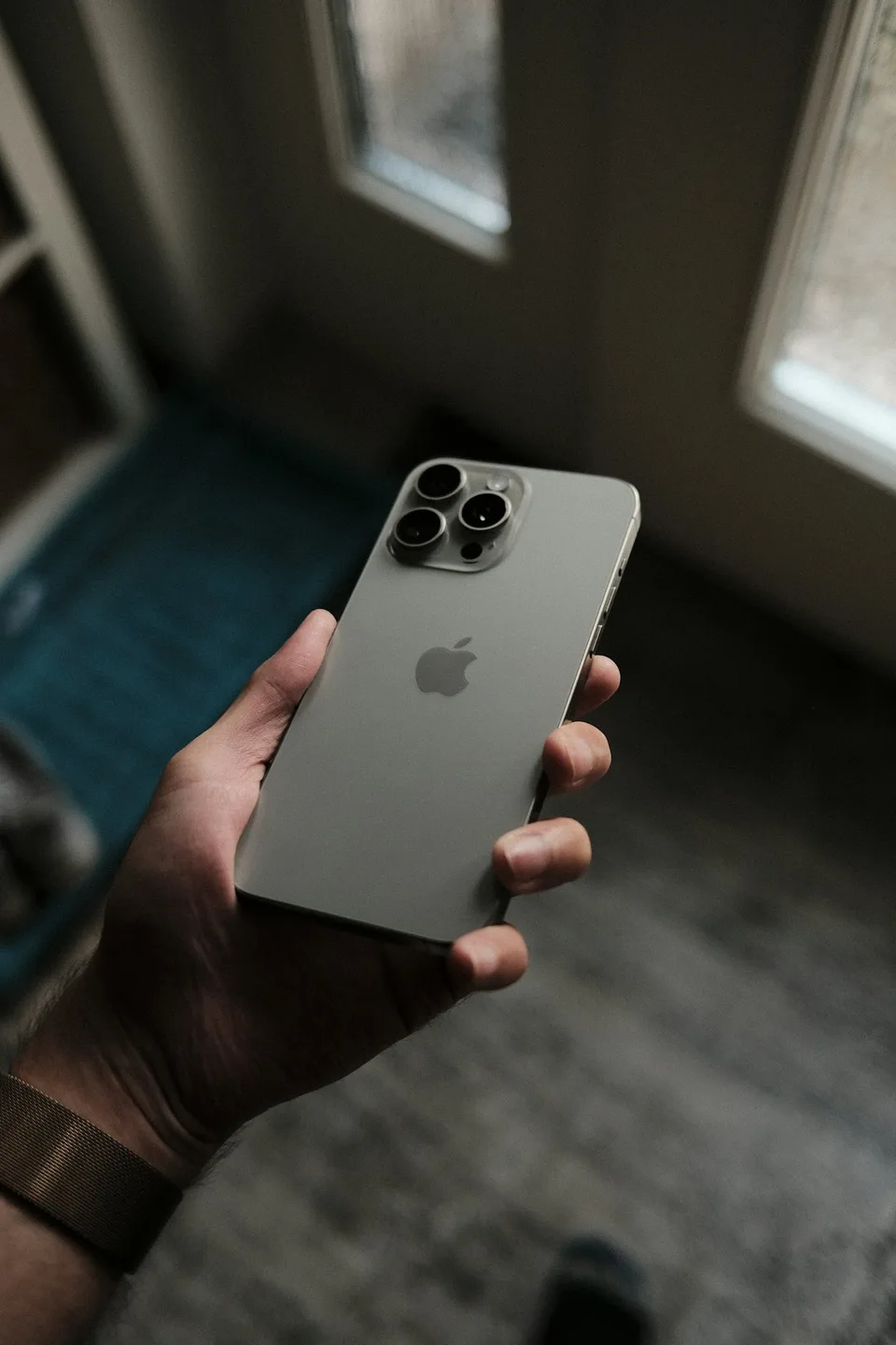 iPhone titane tenu en main (photo d'illustration)
